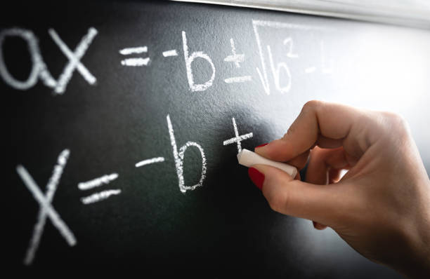 Math equation, function or calculation on chalkboard. Teacher writing on blackboard during lesson and lecture in school classroom. Student or tutor calculating or professor working.